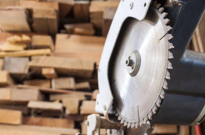 Compound Mitre Saw cutting planks wooden background image